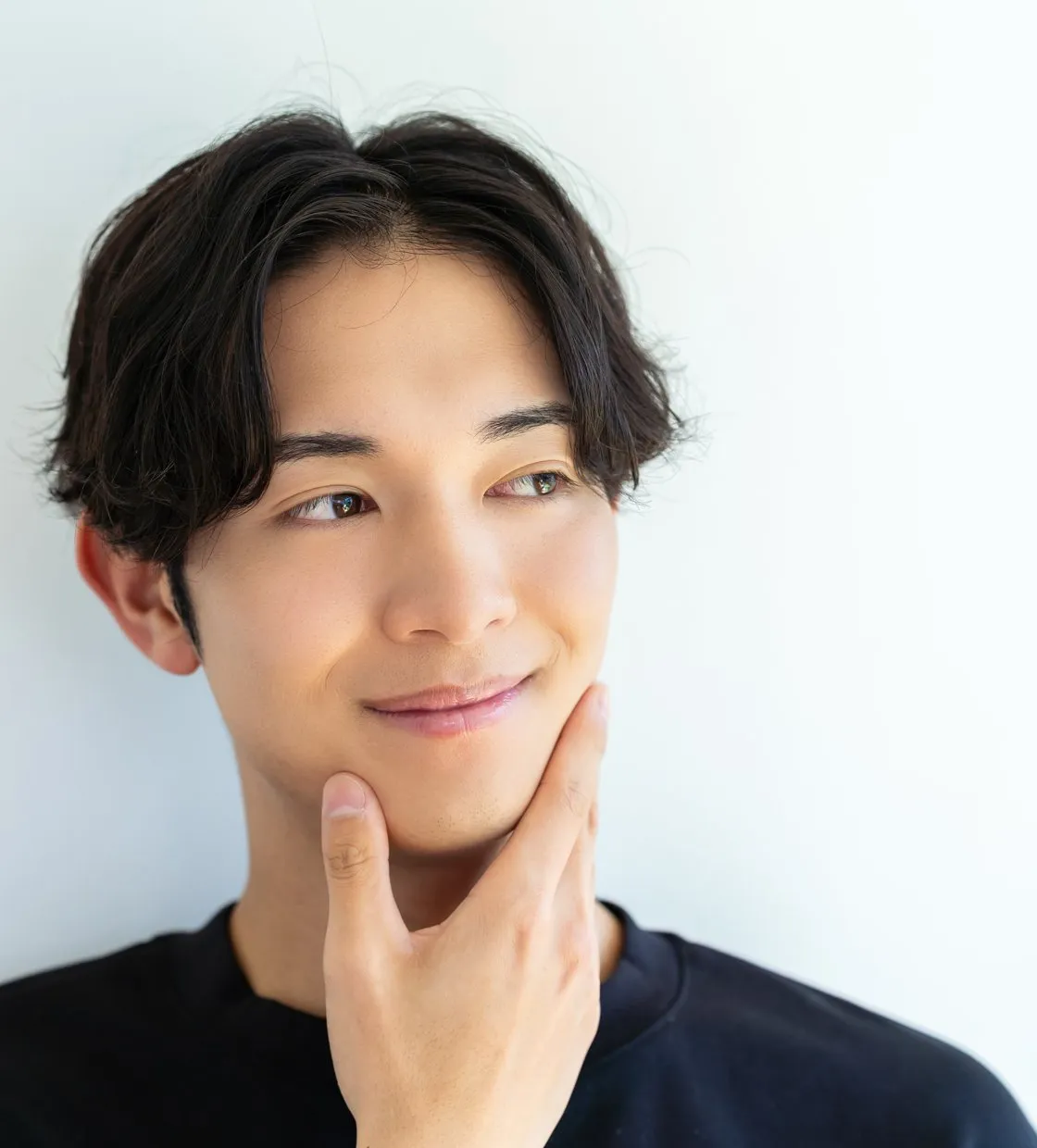 あごに手を当てて微笑む男性